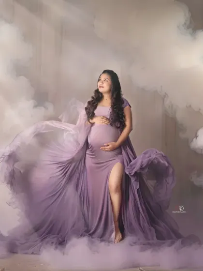 I grow humans, what’s your superpower? This dreamy studio shot with a flowing lavender gown and a cloud-like effect creates a magical and empowering maternity portrait.