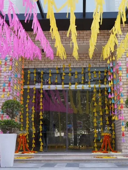 This entrance is a curtain of color. I used hanging strings of colorful paper cones and streamers to create a playful and immersive entryway for a fun-filled event.