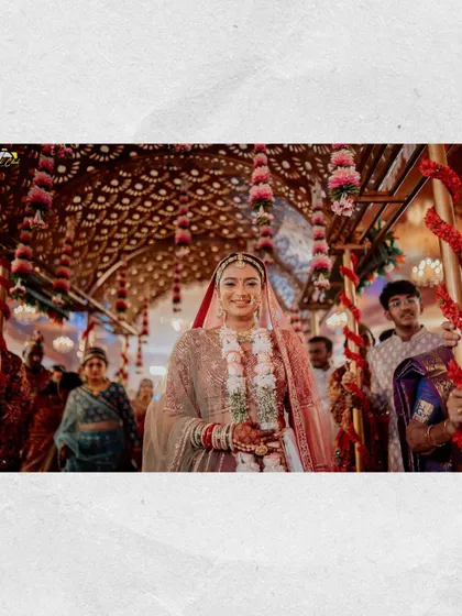 The bride's grand entrance. Walking under a beautifully decorated floral canopy, Maitri looks radiant and happy as she makes her way to the mandap.