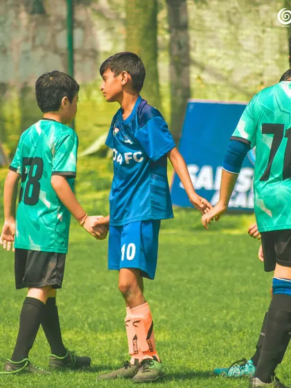 A moment of sportsmanship as two young players shake hands.