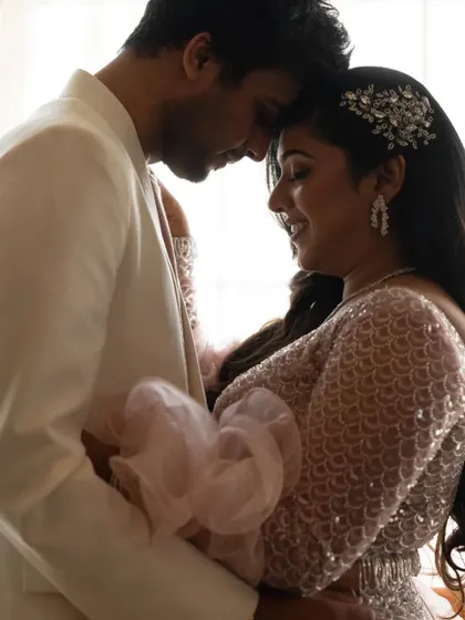 A beautifully lit close-up of the couple in an intimate embrace, highlighting the bride-to-be's sparkling hair accessory.