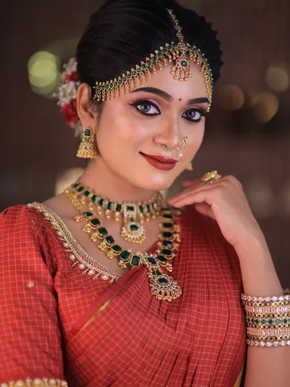 Model Swetha in a red checked silk saree. This traditional drape is perfect for showcasing classic South Indian bridal looks for catalogues or campaigns.