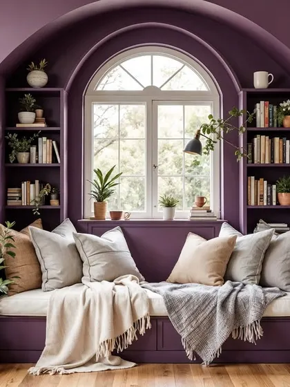 A concept for a cozy reading nook, featuring a built-in bench and bookshelves in a deep purple. The arched window and plentiful cushions make it the perfect spot to curl up with a book.