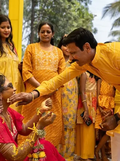 A guest playfully applies Haldi to the bride, capturing the fun and interactive nature of the ceremony.