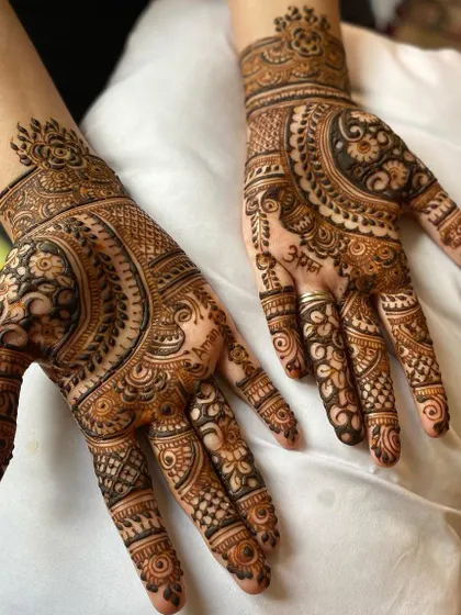 This design features a large, semi-circular pattern on the palm, filled with detailed work. It’s a style that is both traditional and modern.