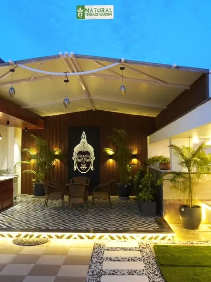 A covered seating area in the Palam Vihar project, featuring a retractable awning, a Buddha art piece, and a built-in kitchenette.