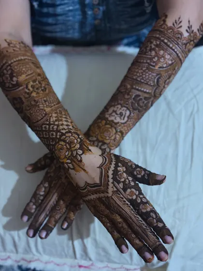 A crossed-hands pose showcasing the symmetry and beauty of this non-bridal henna design.