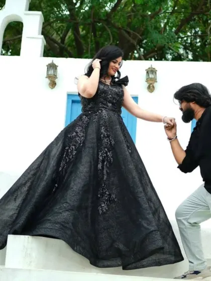 A true gentleman's gesture. He kisses her hand as she descends the steps in a magnificent black sequined ballgown.