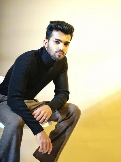 A classic portrait focusing on clean lines and a confident expression. The simple black turtleneck and neutral background ensure all attention is on the subject, making this an essential and versatile shot for any actor or model's headshot collection.
