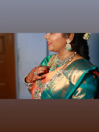 A close-up of the bride's hands, showing her intricate henna and a large statement ring that is part of the rental set.