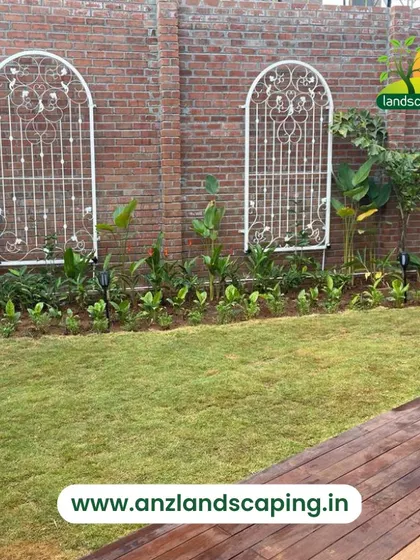 Another angle of the lawn and planting bed, showcasing the healthy green grass and the careful arrangement of plants to create a layered, natural look.