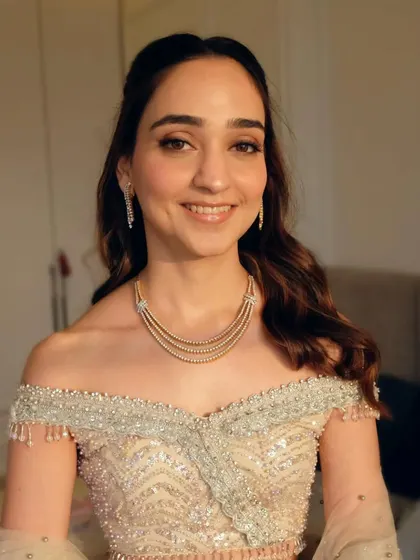 A front view of the half-tie hairstyle, showing how it frames the face beautifully. The soft waves add a touch of glamour.