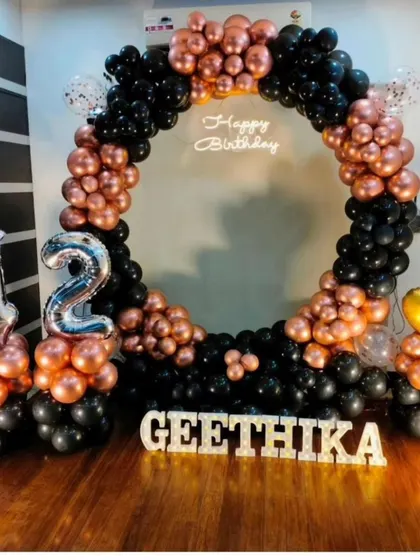 A stylish 42nd birthday celebration with a black and rose gold balloon ring, perfect for a chic and modern party at home.