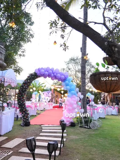 A beautiful garden party entrance with a balloon and floral arch.