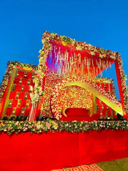 A daytime view of the unique red floral stage, showing the vibrant colors against the blue sky.