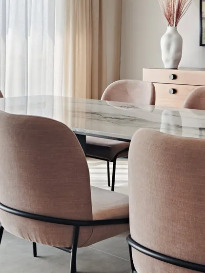 A close-up of the dining chairs in the Maximum City Duplex, showing the contrast between the soft fabric and the sleek, black metal frame.