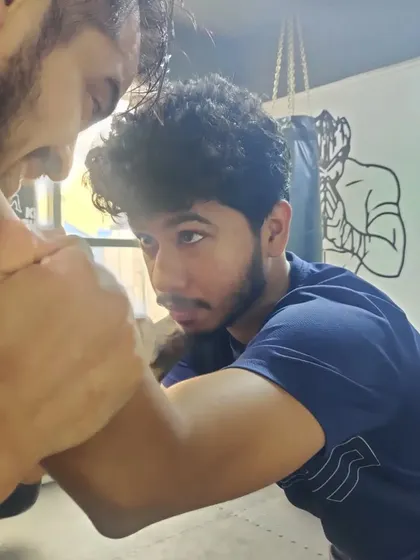 An intense close-up during a grappling session, showing the focus and determination required for ground-based martial arts like BJJ.