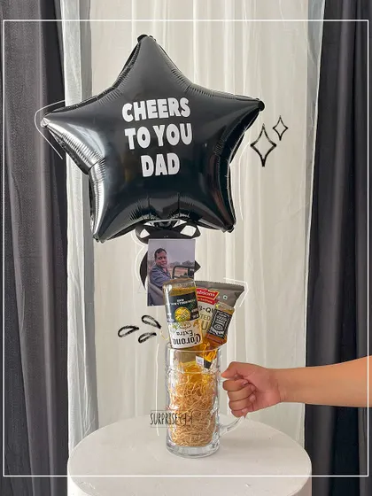 Cheers to you, Dad! This creative Father's Day gift uses a large beer mug as a base for a fun arrangement including snacks, drinks, and a star-shaped foil balloon.
