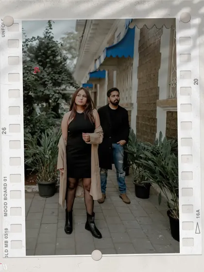 A stylish, editorial-style shot of the couple on a Mumbai street, framed by a film border.