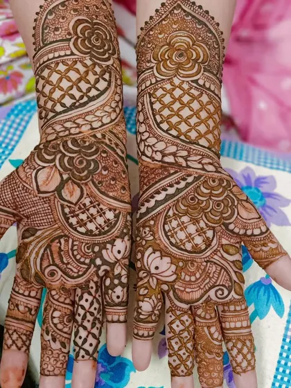 A lovely pair of hands decorated with complementary designs. The patterns include floral elements, jaali nets, and lotus-inspired shapes for a full and festive appearance.