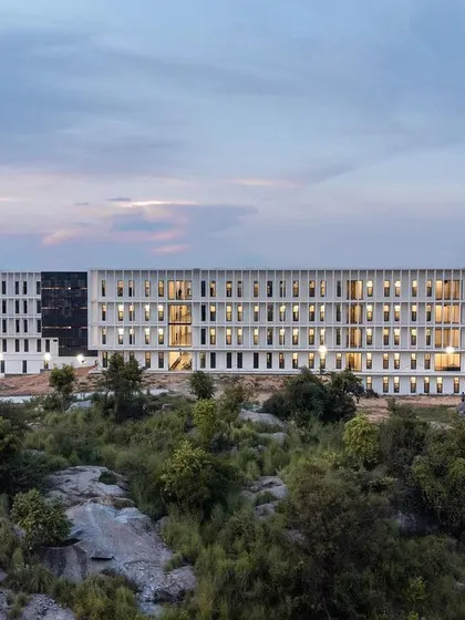 This factory workers' housing project was designed for thermal comfort and psychological well-being. The facade's deep, rhythmic openings provide natural ventilation and shade to each unit, while the building's placement within the natural, rocky landscape offers a connection to nature.