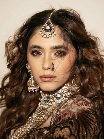 An intense and captivating bridal close-up. The wind-swept hair and direct gaze make this a powerful and dramatic beauty shot.