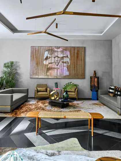 The living room at Baid Residence is a symphony of sophistication, featuring a Henge light, furniture from Alsorg, and a captivating wooden chaise from Phantom Hands. The space is anchored by a luxurious rug from Jaipur Rugs.