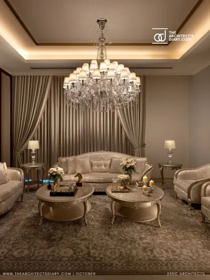 An intimate seating area within The Ivory Royale, showcasing the plush, custom-made furniture and the warm glow of a crystal chandelier. This space is designed for comfortable, elegant conversation.