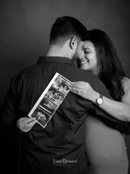 A sweet hug and a peek at the baby's first pictures. This black and white portrait beautifully captures the joy and intimacy of sharing this special time.