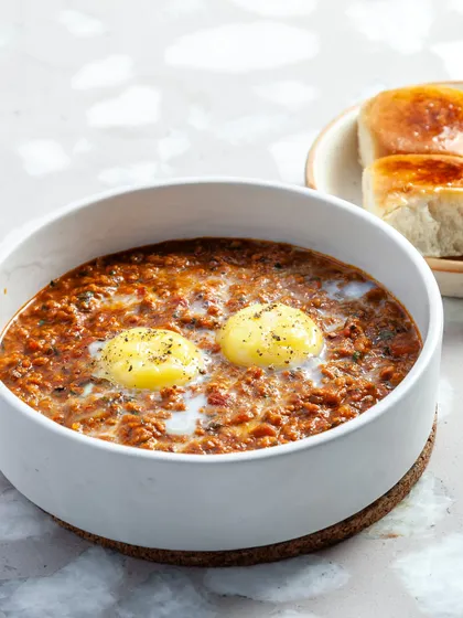 Our Tawa Chicken Rara with a baked egg and maska bun. It's a hearty, satisfying dish perfect for any meal, available for dine-in or delivery.