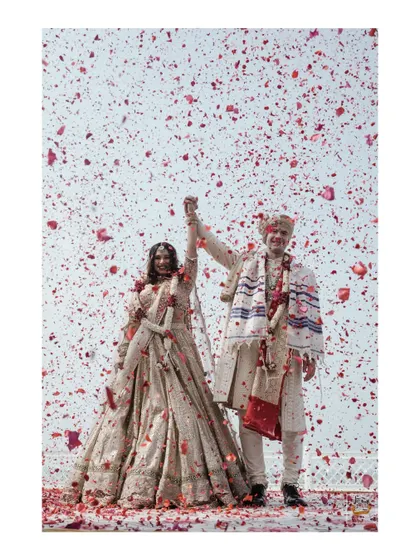 A magical moment as the couple is showered with rose petals after their beach ceremony in Goa. This is pure celebration.