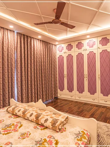 A bedroom with lavender-paneled wardrobes and a classic coffered ceiling, creating a soft, romantic feel.