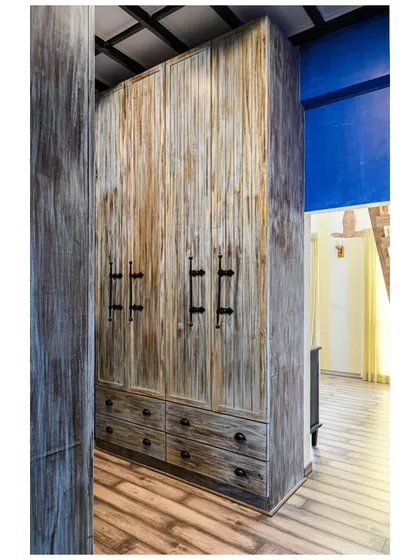 This tall, distressed-finish wardrobe adds to the rustic, medieval theme of the home, providing grand scale and texture.