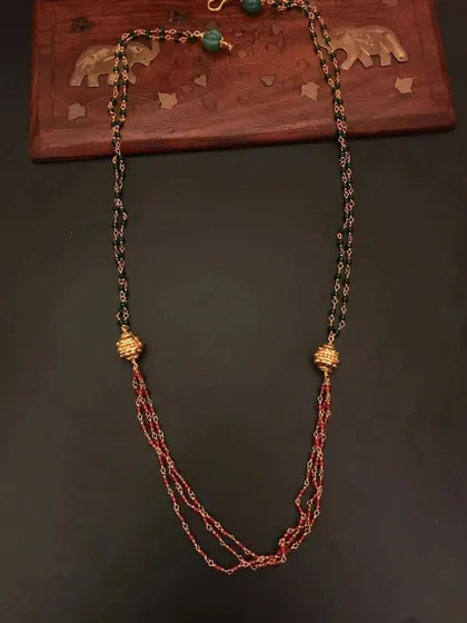 This 92.5 silver gold-plated beaded necklace features a mix of black and red beads with golden accents. It's a stylish and modern piece for daily wear.