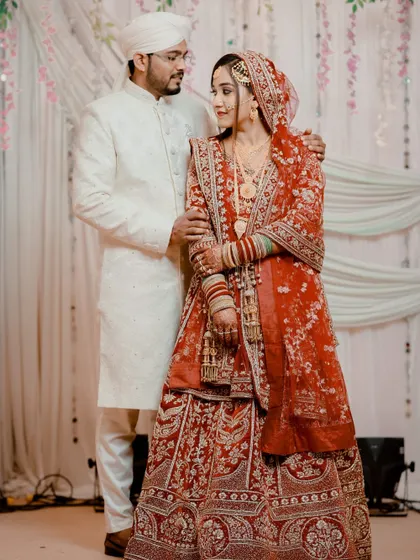A beautiful couple portrait. My bride looks elegant and poised in her red embroidered lehenga, with makeup that enhances her features without overpowering them.