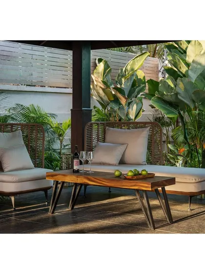 The outdoor lounge furniture is chosen for both comfort and style, with natural materials that complement the garden setting.