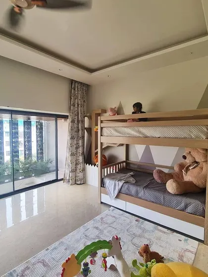 We love designing for our little clients. This children's bedroom features a custom bunk bed with built-in stairs that double as storage, set against a playful mountain-themed wall mural. A large window provides plenty of natural light for play.