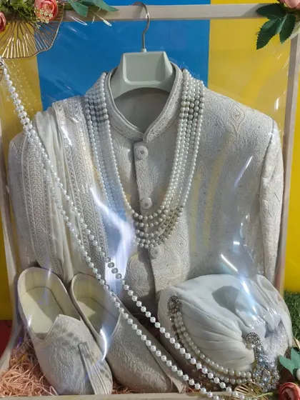 The groom's outfit is just as important. Here, I have carefully packed a sherwani along with the matching jutti and pagdi. The presentation is clean and elegant, ensuring the groom's attire looks sharp for the main event.
