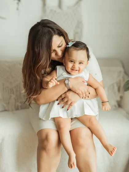 A tender moment between a mother and her baby girl, full of smiles and cuddles.