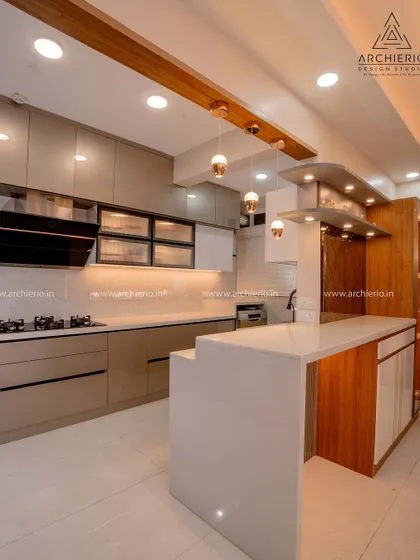 This open kitchen features a breakfast counter that doubles as extra prep space. The combination of wood and white finishes creates a warm and contemporary look.