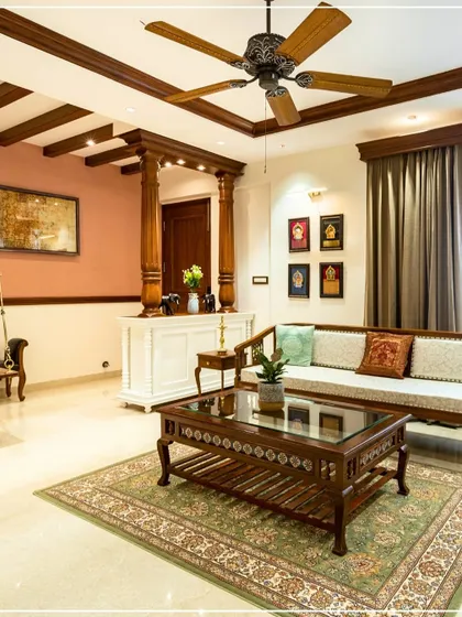 A Kerala-inspired living room with a traditional wooden sofa, carved coffee table, and exposed ceiling beams, creating a warm and authentic atmosphere.