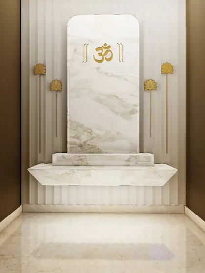 A concept for a minimalist Puja space in a modern home. The design uses a single slab of white marble with a gold 'Om' inlay, flanked by elegant lotus-motif lamps, creating a clean and sacred corner.