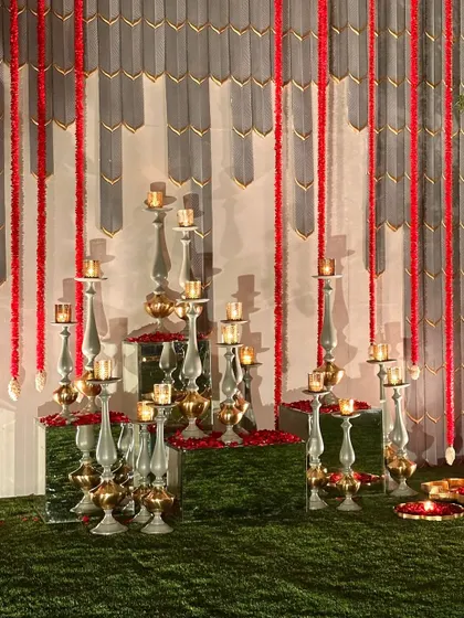 A modern photo backdrop with a grey textured wall and red floral strings.