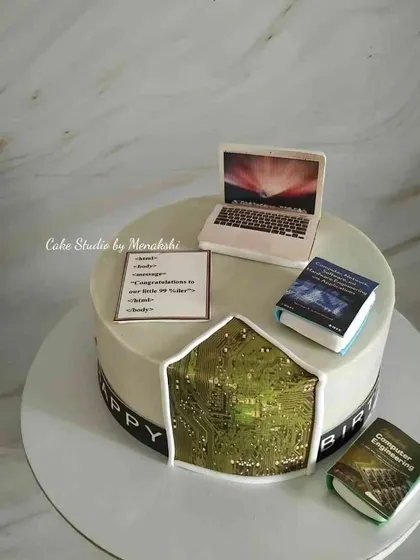 A detailed cake for a software programmer. It features a laptop with code, computer engineering books, and a circuit board design.