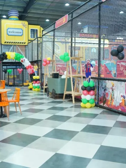 The party area is ready for the guests, with balloon columns featuring football stars, creating an exciting atmosphere for a sports-loving kid.
