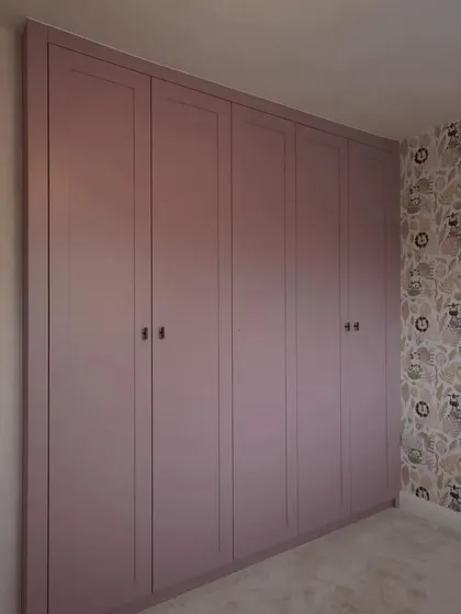 The closed wardrobe presents a seamless and elegant facade, with subtle paneling details that add a touch of classic charm to the modern design.