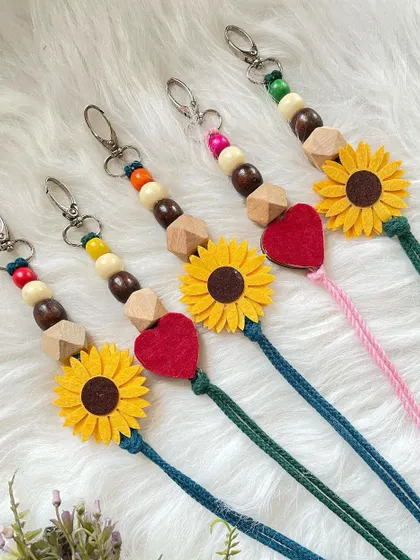 My custom lanyards, perfect for holding keys or an ID badge. This design features a knotted cord decorated with wooden beads and a cute felt sunflower or heart accent.
