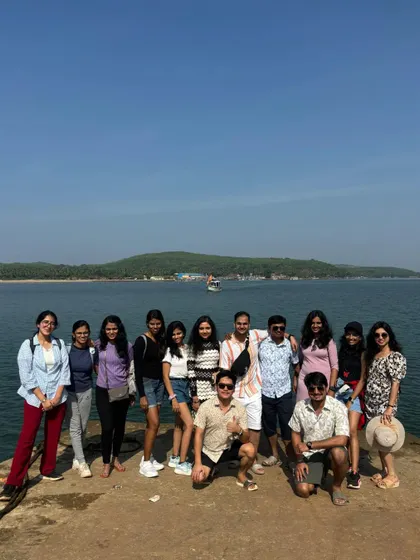 A group of travelers posing on a pier in Gokarna on a bright sunny day.