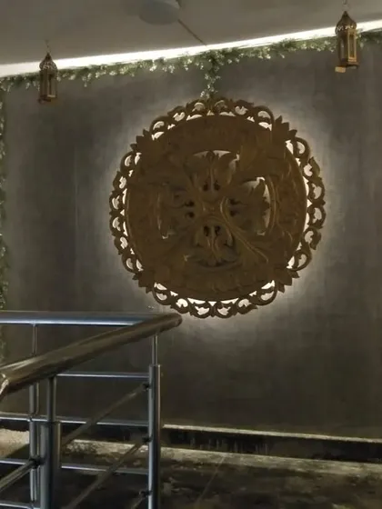 A backlit wooden art medallion at the staircase entrance, welcoming guests with a touch of artistic elegance.