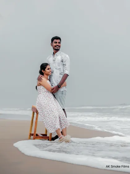 The waves washing over the shore add a dynamic and romantic element to this beach portrait.